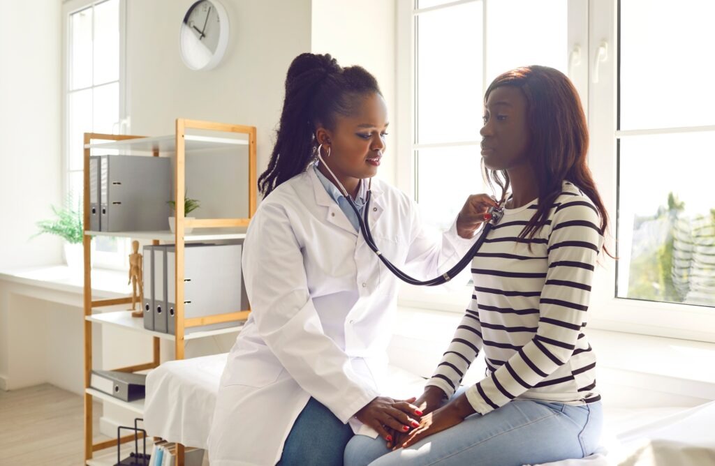 A doctor in a white coat takes notes during a patient consultation, emphasizing communication in a healthcare setting.